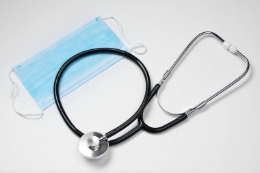 Bir doktor için steteskop bir hastanın kalbini ve akciğerlerini dinlemek ve beyaz arka planda mavi bir tıbbi yardım almak için kullanılır. Sağlık hizmetleri kavramı