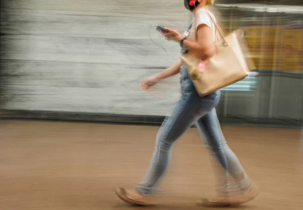 Motion blur strength, The woman walks with the bag to the right