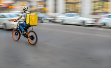 Bisikletli kuryenin siparişi teslim etmek için acelesi var.