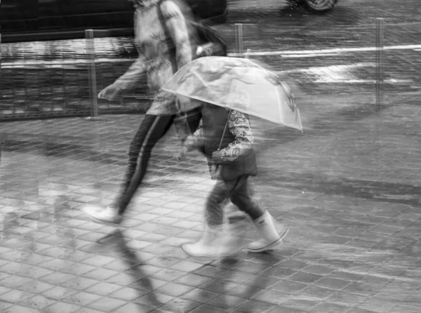 母亲和孩子在雨中移动 — 图库照片