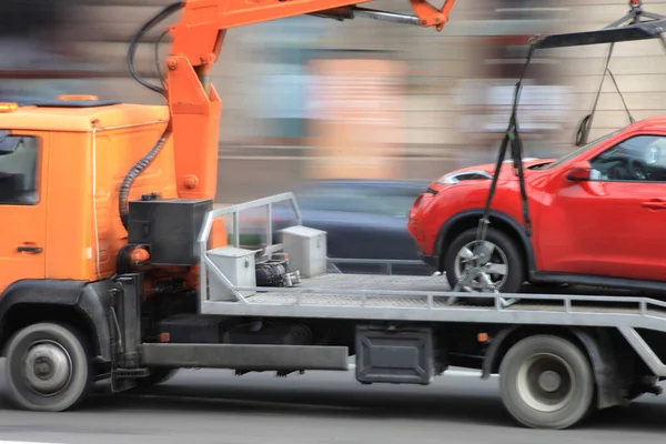 Motion blur, car tow truck rides on a city street