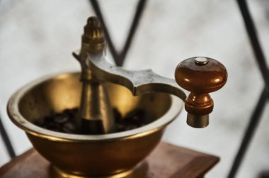 Eski ahşap pencere üzerinde kahve çekirdekleri ile kahve öğütücü antika. Pencerenin dışında kış manzara bulanık görüntü.