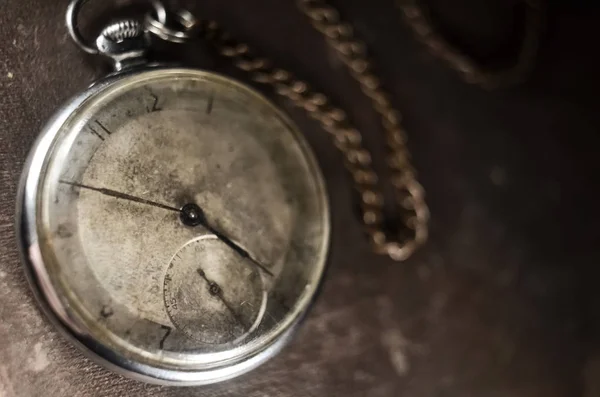 antique pocket watch on a vintage photo album. selective focus