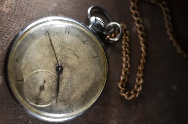 antique pocket watch on a vintage photo album. selective focus