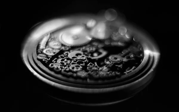 Black and white photography. Skeleton hours. Antique antique clockwork, jewelry engraving. mechanical pocket watch close-up, selective focus.