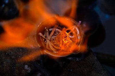 gümüş veya altın değerli metal eritme. kuyumcu işyerinde bir meşale ile bir pota içinde takı remelting. takı yapımı
