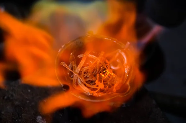 smelting precious metal of silver or gold. remelting of jewelry in a crucible with a torch at a jewelers workplace. jewelry making