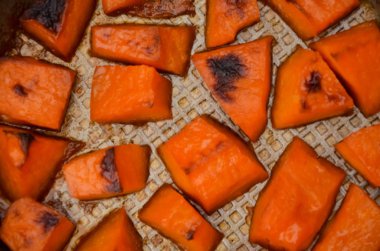  Cadılar Bayramı yemeği için şekerle pişirilmiş balkabağı parçaları. Sağlıklı vejetaryen yemekleri. Sonbahar sıcak yemeği tatlı olarak. Seçici odaklanma, yakın plan. Boşluğu kopyala.