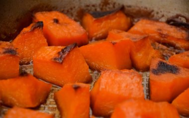  Cadılar Bayramı yemeği için şekerle pişirilmiş balkabağı parçaları. Sağlıklı vejetaryen yemekleri. Sonbahar sıcak yemeği tatlı olarak. Seçici odaklanma, yakın plan. Boşluğu kopyala.