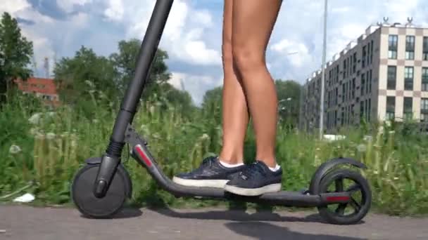 Электрический скутер. 4К крупным планом видео привлекательной женщины за рулем электромобиля . — стоковое видео