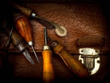 Eski bir evrak çantası üzerinde eski saraçlık araçları