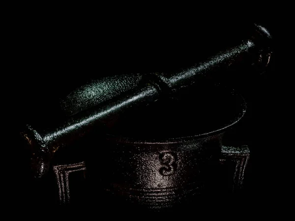 Old black metal mortar detail with black background