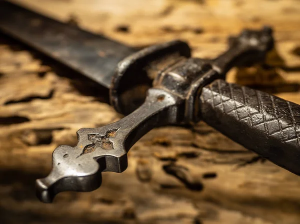 Detalj av medeltida svärd handtag och vakt på trä bakgrund — Stockfoto