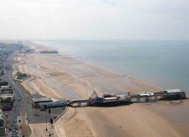 Blackpool, Lancashire, İngiltere - 7 Haziran 2018: kuzeye bakan blackpool'un havadan görünümü, sahilden İrlanda denizine uzanan iskeleler ve yollar ve binalarla alçak gelgitte plajı gösteriyor.