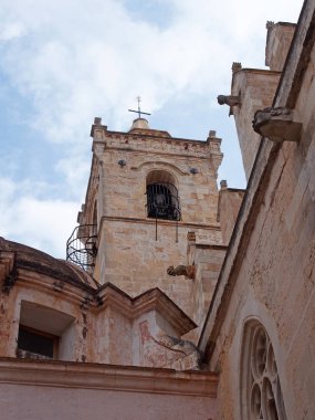 Mavi bulutlu gökyüzüne karşı Menorca La Ciutadella Santa Maria Katedrali çan kulesi ve gargoyles yakından görünümü