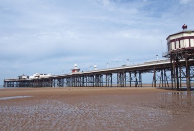 parlak güneşli yazlar gününde düşük gelgit görünür plaj ile büfeler ve binalar ile blackpool tarihi viktorya kuzey iskelesi görünümü