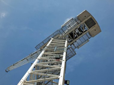 mavi bir gökyüzüne karşı büyük bir beyaz modern kule inşaat vinç yukarı dikey görünümü bakıyor