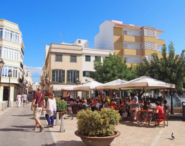 Ciutadella, Menorca / İspanya - Ekim 12018: Placa d 'Artruix Ciutadella' daki çeşmenin etrafındaki insanlar, çevresindeki kafeleri olan eski Menorca başkenti