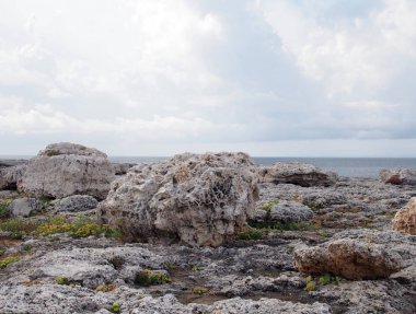menorca İspanya seyahat veya tatil arka plan ve beyaz bulutlar ile bir denize karşı engebeli kıyı kayalar