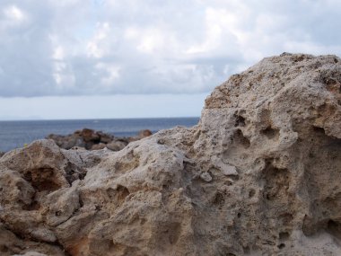 menorca İspanya seyahat veya tatil arka plan beyaz bulutlar ile parlak gökyüzü ile derin mavi denize karşı engebeli kayalar