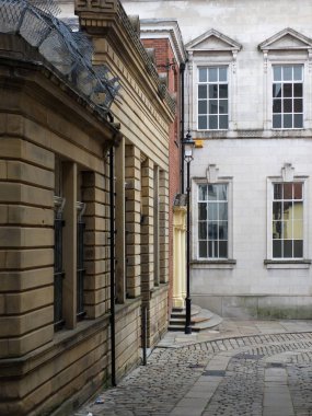 rochdale şehir merkezinde arnavut kaldırımlı bir sokakta eski binalar keskin bir köşede yokuş aşağı bakıyor