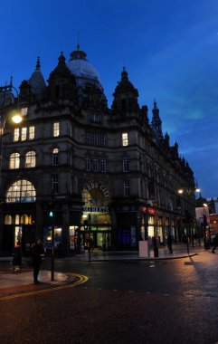 Leeds, İngiltere - 18 Ocak 2018: Leeds'teki tarihi kirkgate pazarının dışındaki insanlar tarihi binayı aydınlatan ışıklarla geceleyin