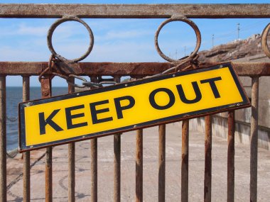 Sarı, denize giden yolu kapatan paslı bir metalde 