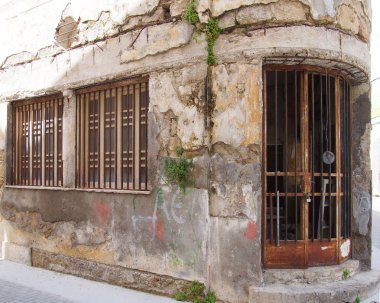 harap kırık eski eski terk edilmiş ticari mülkiyet bir köşede kırık eski eski terk edilmiş ticari mülkiyet ve lefkoşa Kıbrıs çatlaklar büyüyen yosun ile kapı ve pencereler arasında paslı demir çubuklar