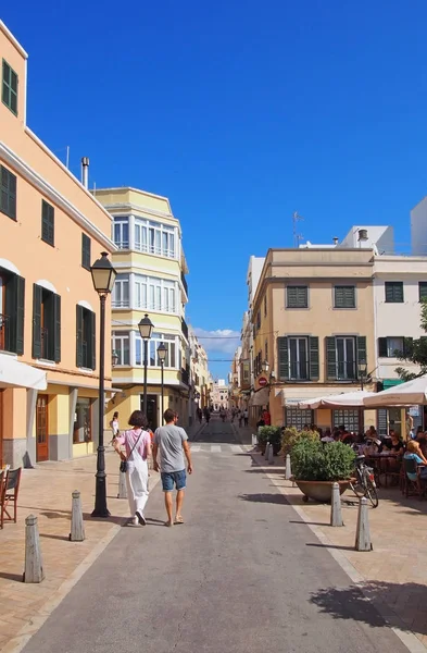 Lidé, kteří chodí po pěší zóně a sedí v venkovní kavárně v Ciutadella Menorca — Stock fotografie