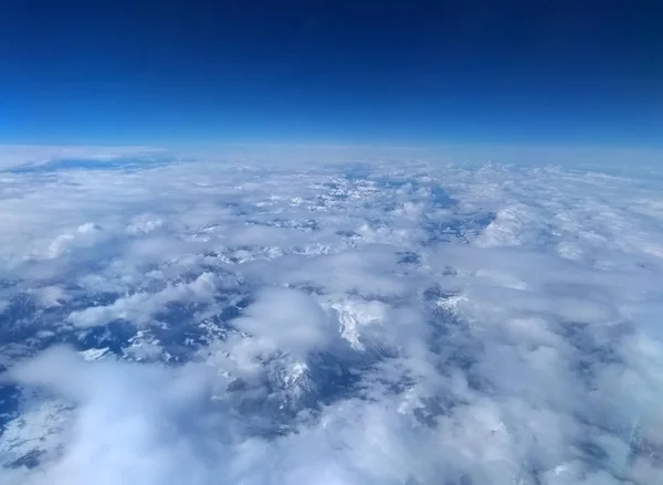 Vista Aérea Montañas Nevadas Alpinas Cubiertas Nubes Blancas Cielo Azul —  Fotos de Stock