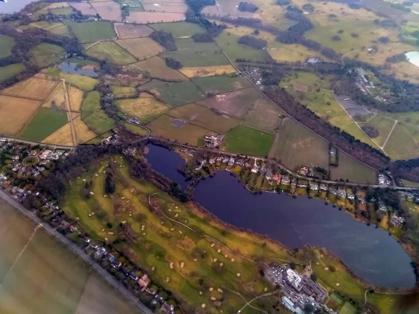 Cheshire İngiltere'de kırsal çevrili bir göl ve bir golf sahası yuvarlak inşa evlerin havadan görünümü