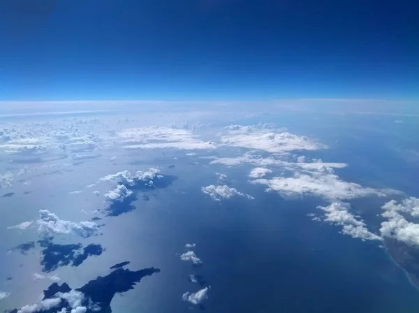 明るい青空と雲が水に映る飛行機から撮影した地中海の航空写真と 画像の下部にある島 — ストック写真