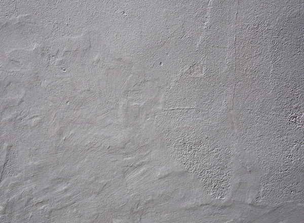 ひび割れと風化した表面を持つ不均一な摩耗した表面を持つ薄い灰色の粗い質感の壁の背景 — ストック写真