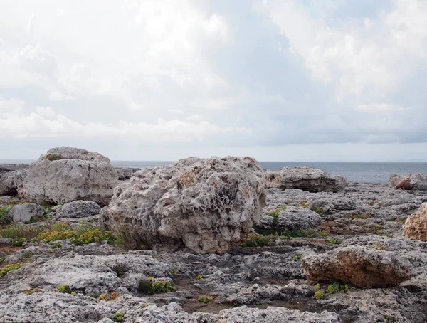 menorca İspanya seyahat veya tatil arka plan ve beyaz bulutlar ile bir denize karşı engebeli kıyı kayalar