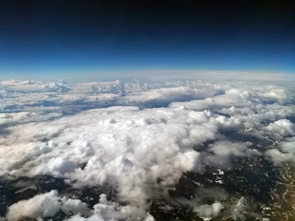 云覆盖的山景鸟瞰图 在绿色的山丘上可以看到雪 天空暗 地平线上可以看到地球的曲率 — 图库照片