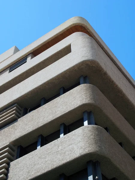 mavi gökyüzüne karşı dokulu yuvarlak köşeleri ile acımasız bir beton beton kule blok köşesi
