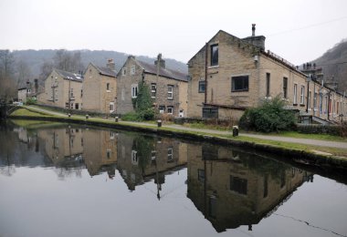kışın suda yansımaları ile Hebden köprüde rochdale kanalı yanında teraslı evlerin sokakları