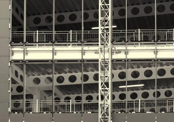 Monochrome image of a large construction site with steel framework and girders with fences and building hoist — Stock Photo, Image