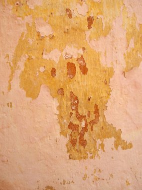 pembe kırmızı ve sarı boya soyma katmanları ile eski kaba boyalı duvar