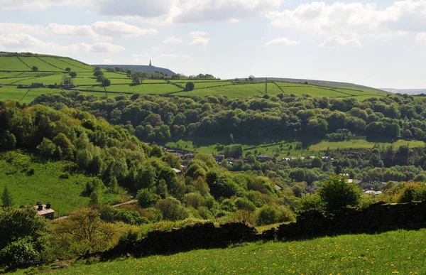 Wiosnę Pennine wsi w Calderdale West Yorkshire z typowymi polami wzgórza, lasy, domy i stoodley szczupak pomnik w oddali — Zdjęcie stockowe