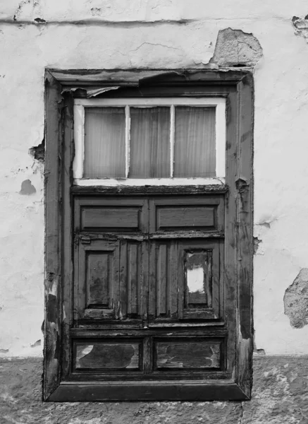 Velha janela rasgada em uma casa decadente com madeira intemperizada e pe — Fotografia de Stock