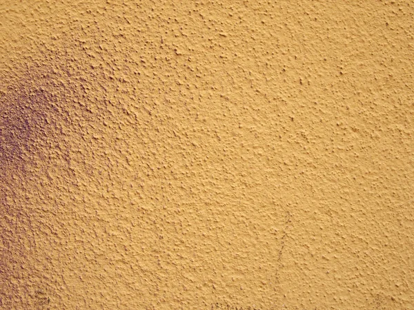 Dağınık mor sprey boya ipuçları ile soluk grenli dokulu sarı duvar arka plan — Stok fotoğraf