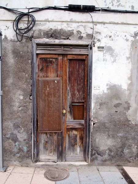 broken patched old brown door in rotten frame in an abandoned de