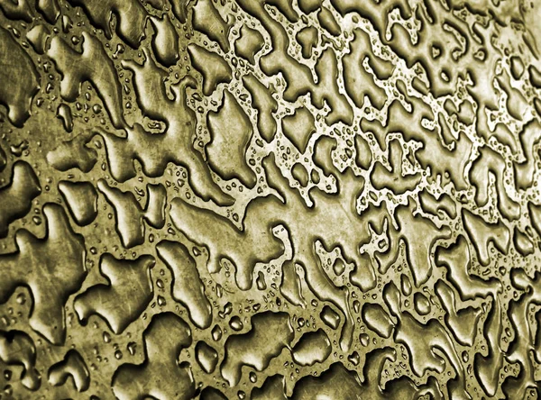 Vatten efter regn på ett guld metalliskt stål yta gör en abst — Stockfoto