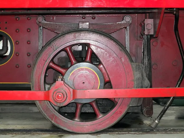 Wheel of an old steam locomotive painted red with coupling rods — 스톡 사진