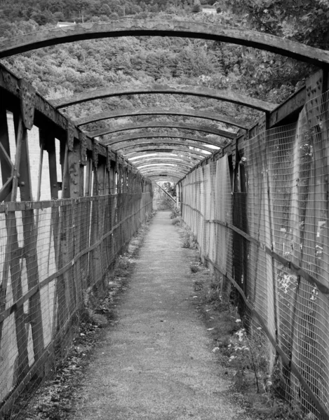 Velho metal enferrujado pedestre passarela atravessando uma linha ferroviária — Fotografia de Stock