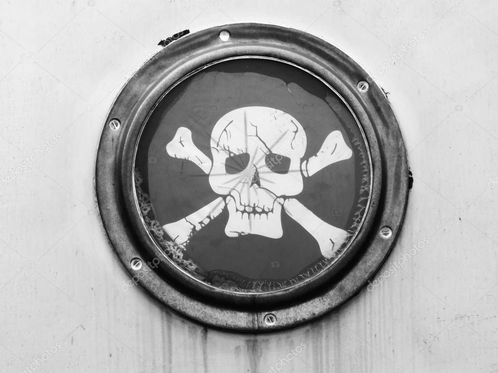 brass porthole on ship with pirate flag