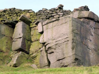 Yorkshire bozkırda üst boyunca bir taş duvar ile büyük bir kaya çıkıntı kayalar