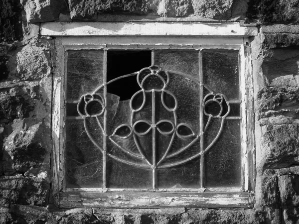 abandoned derelict broken old decorative lead glass window in a