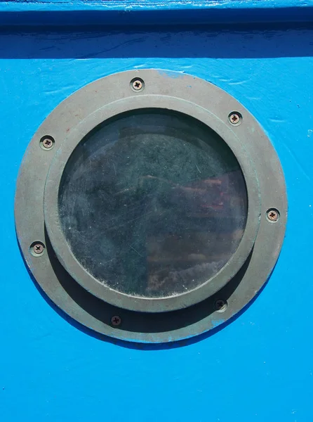 Close up of rusty distressed porthole on a blue wooden boat with — Stock Photo, Image